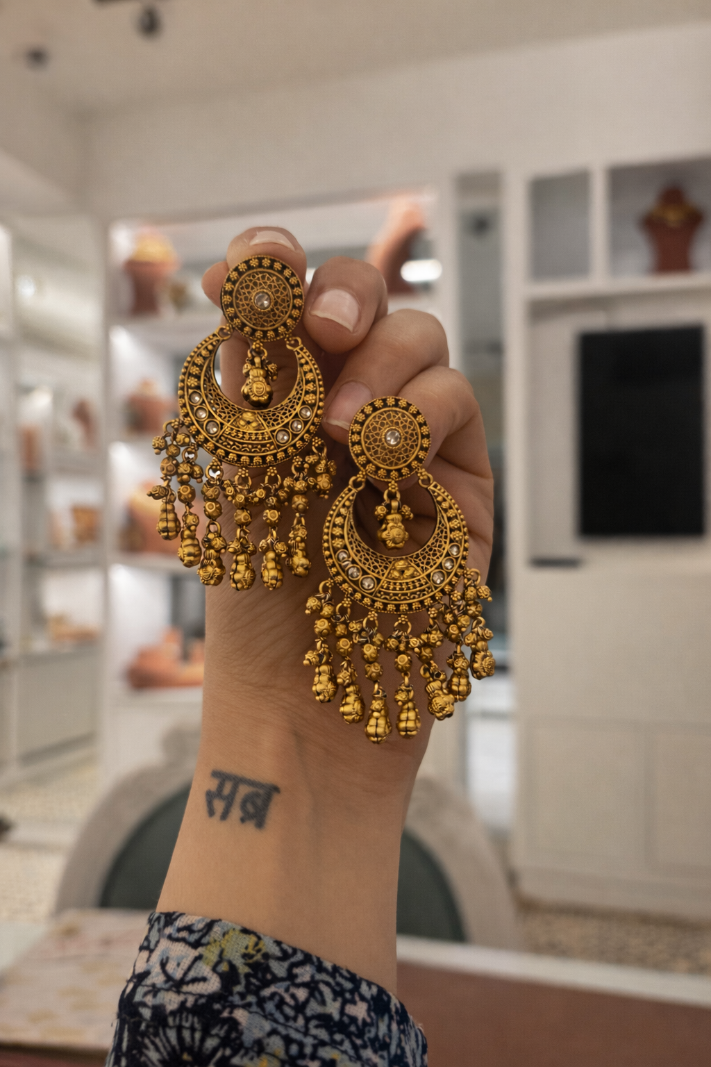 Gold earrings on a light pink background