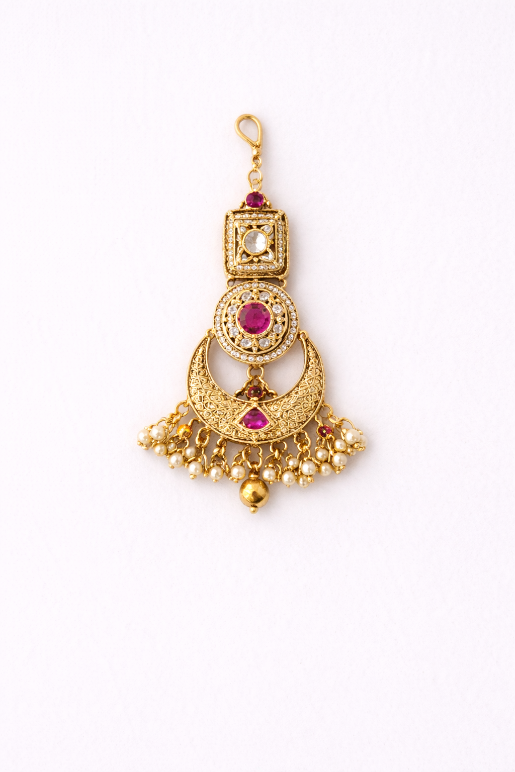 Gold tikka with red gemstones on a white background