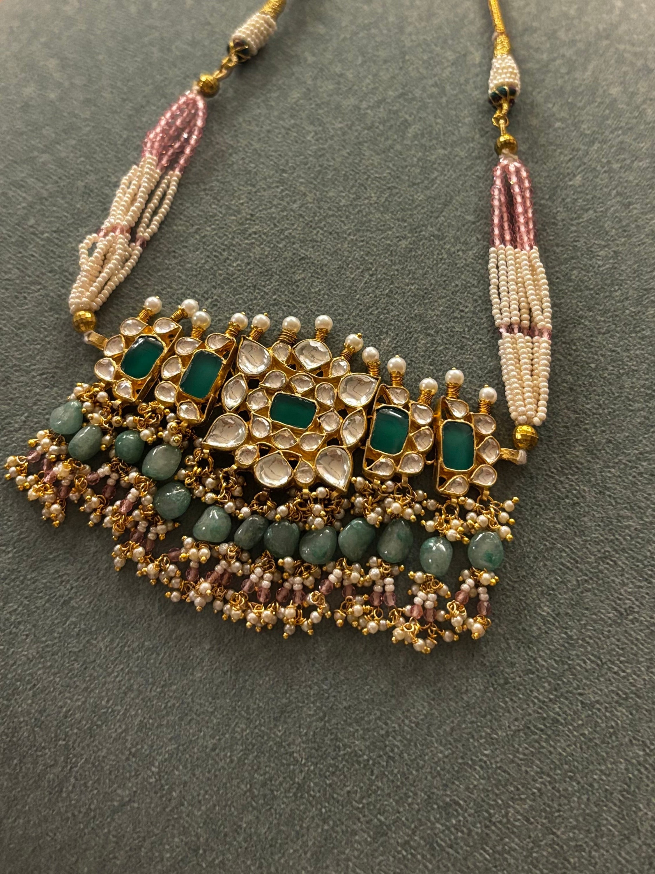Handcrafted emerald green Polki choker necklace with pearl and pastel bead detailing, adjustable dori, and matching stud earrings by Naazuk Jewels.