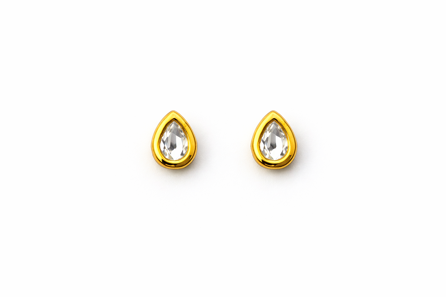 Gold teardrop-shaped earrings with clear gemstones on a white background