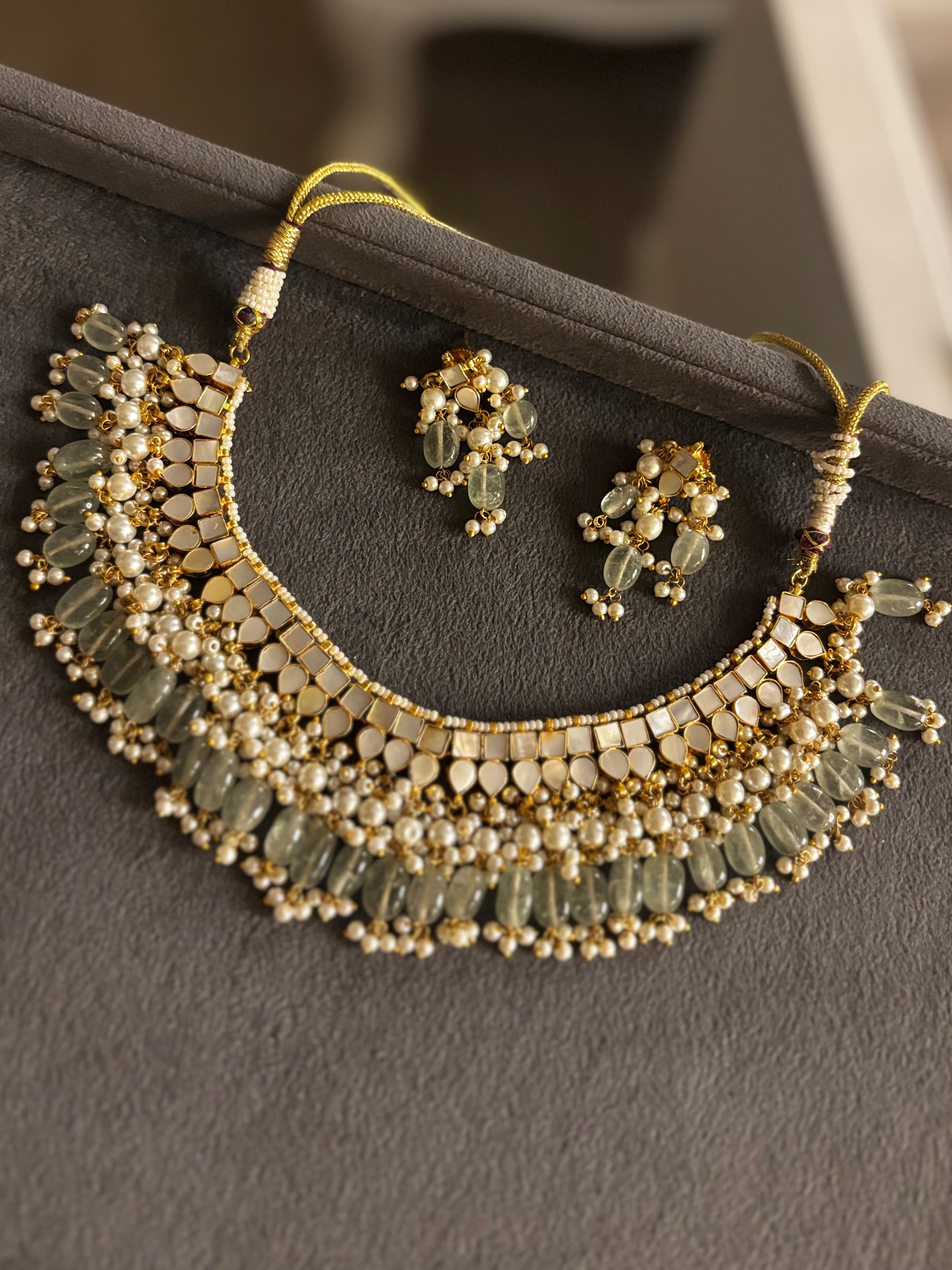 Handcrafted Mother of Pearl Polki collar necklace with pearl detailing, translucent gemstone accents, matching earrings, and adjustable dori by Naazuk Jewels.