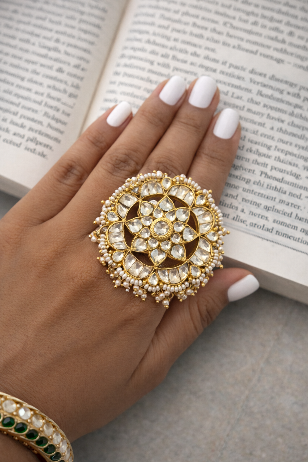 Hand wearing a gold and diamond ring on an open book