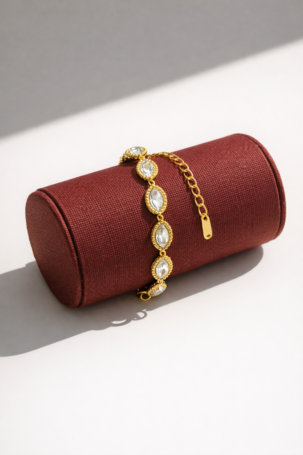 Gold bracelet on a red jewelry roll with a white background