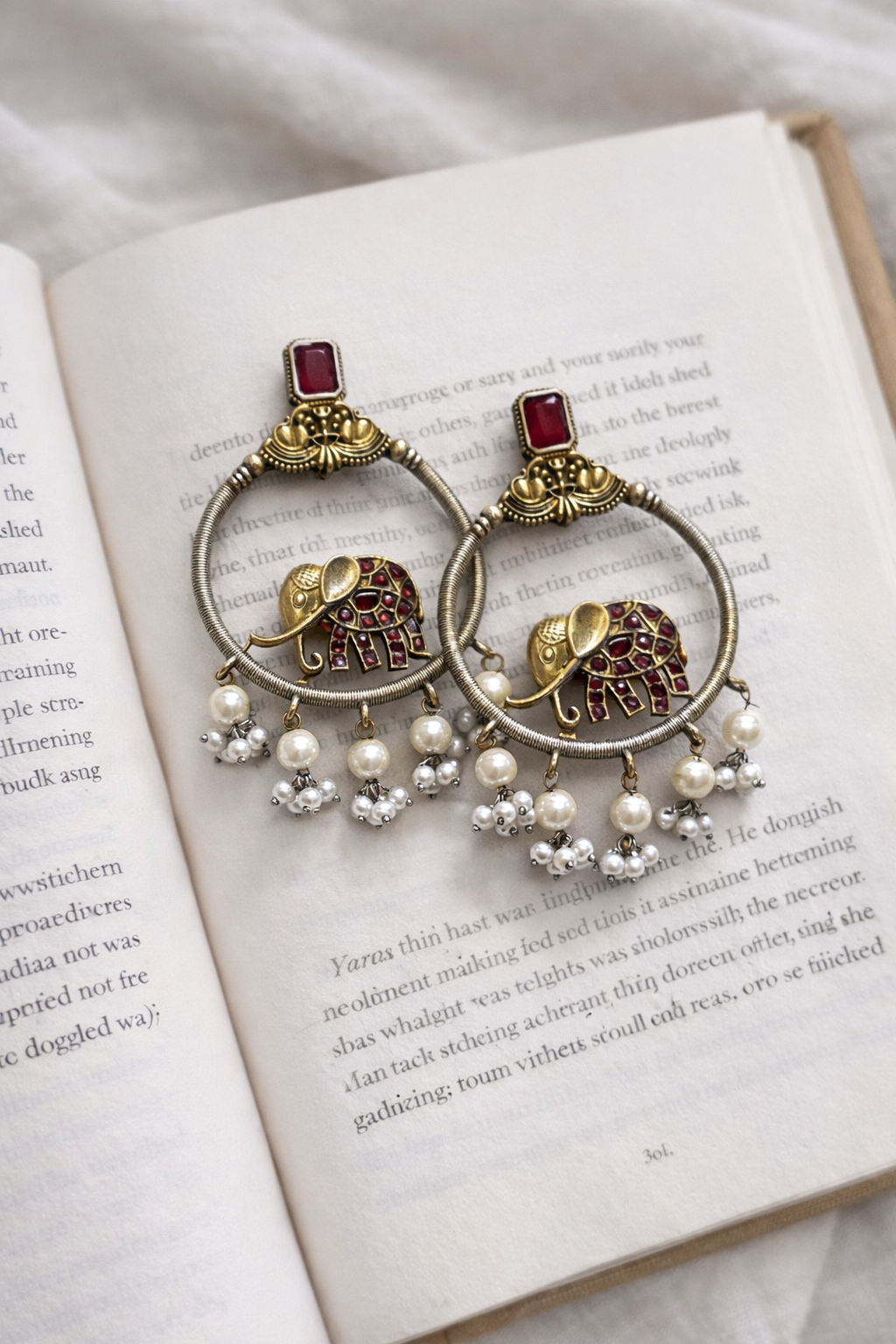 Close-up of a person wearing a decorative earring with a hand adjusting it.