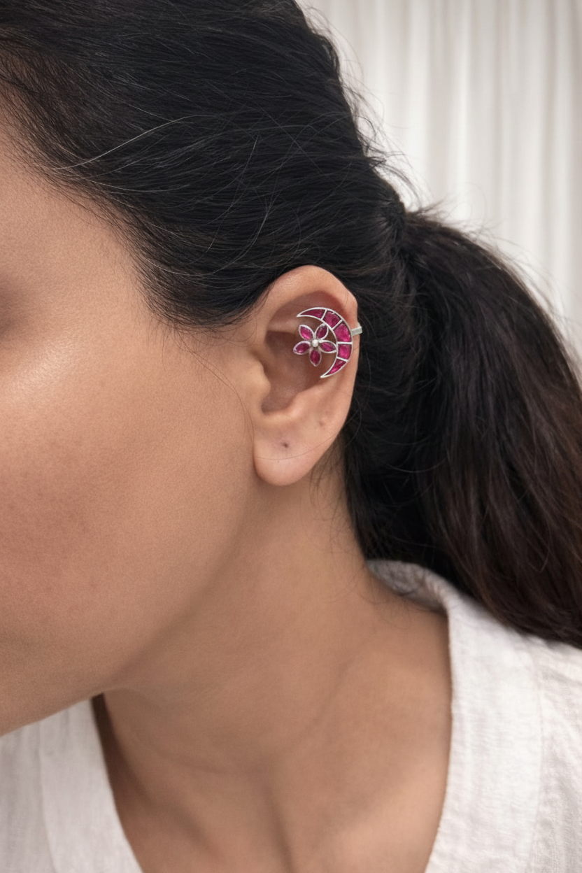 Close-up of an ear wearing a floral earring with a white background