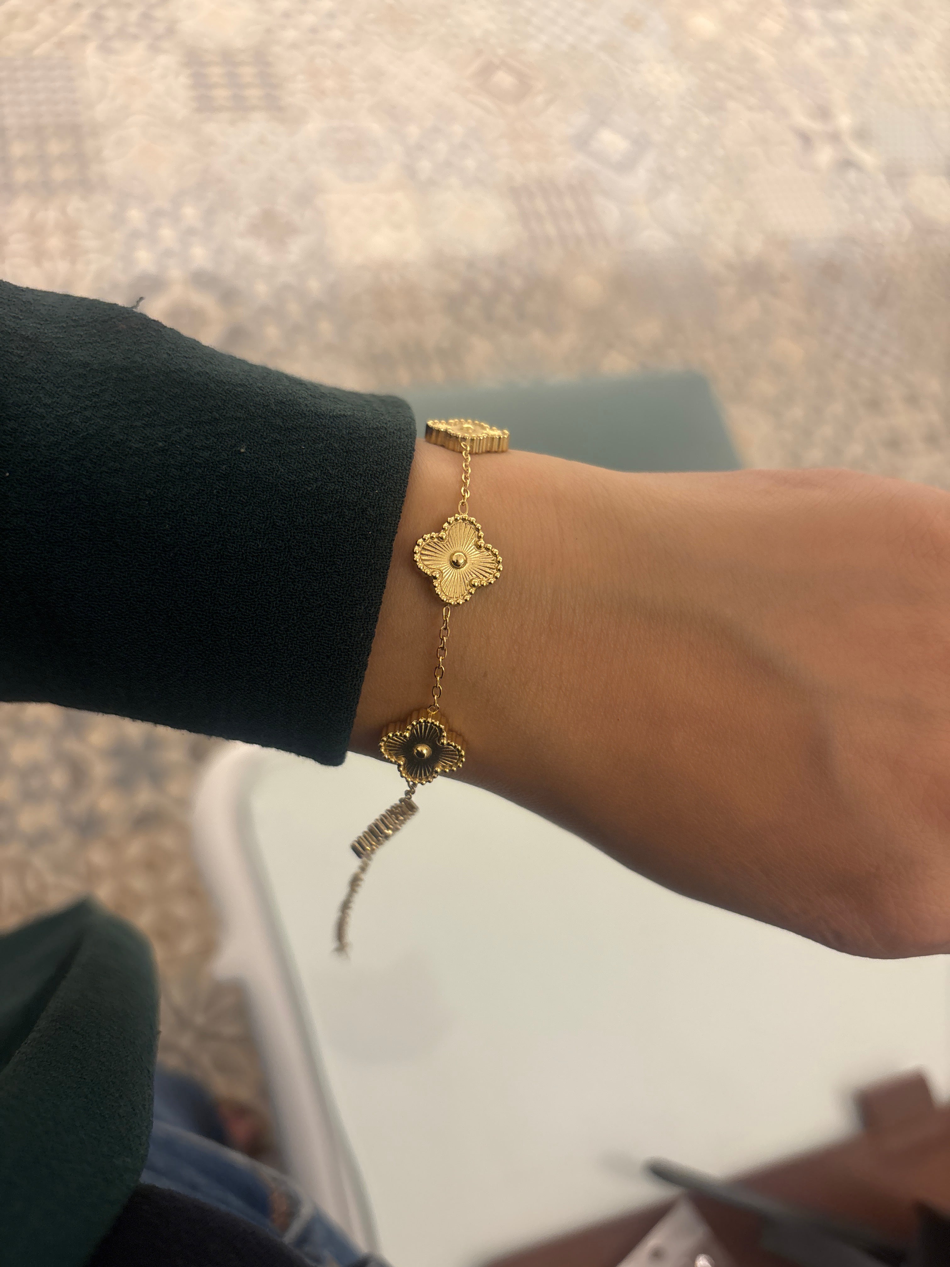 Gold bracelet on a wrist with a blurred background