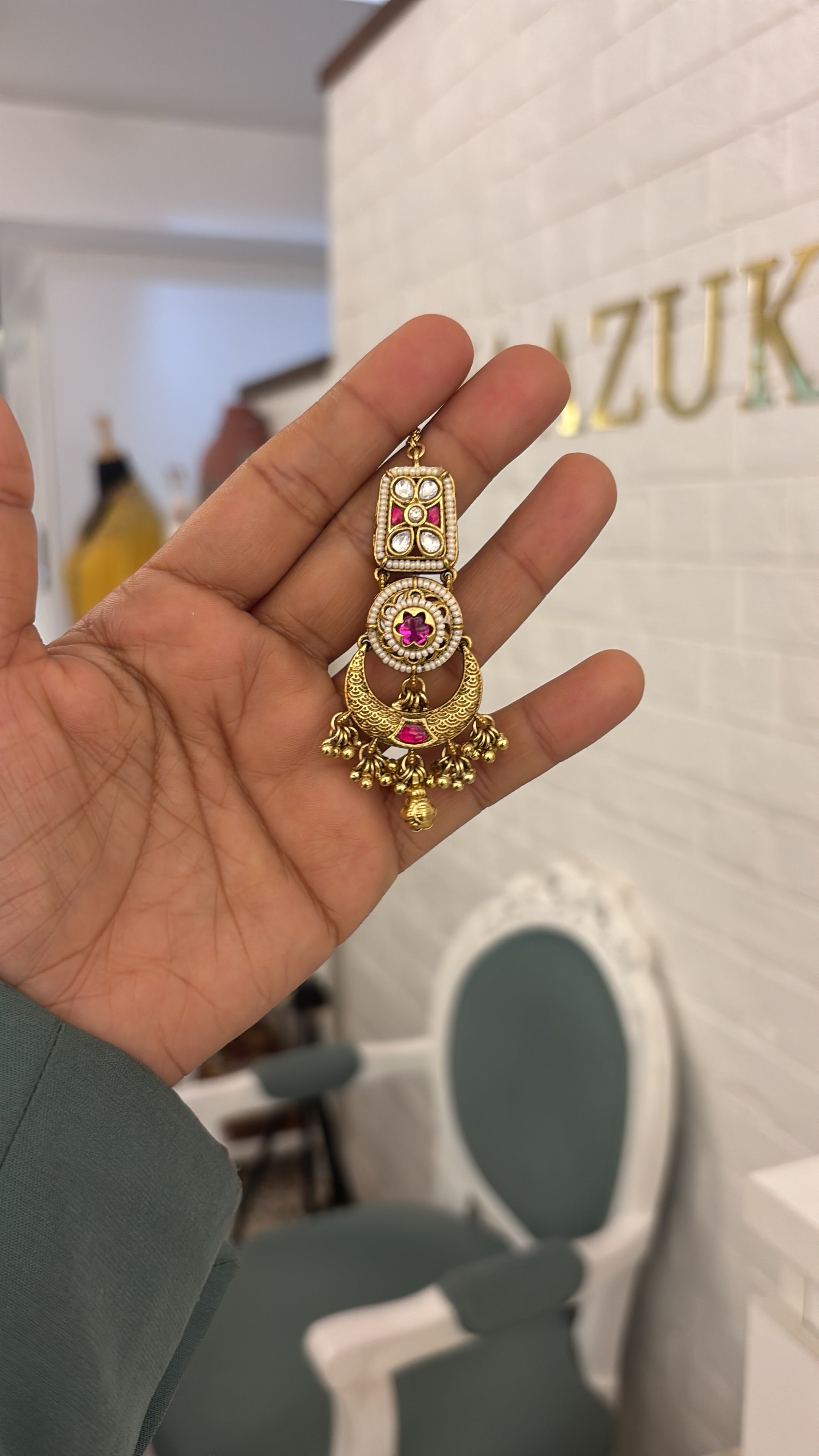 Gold tikka with red gemstones on a white background