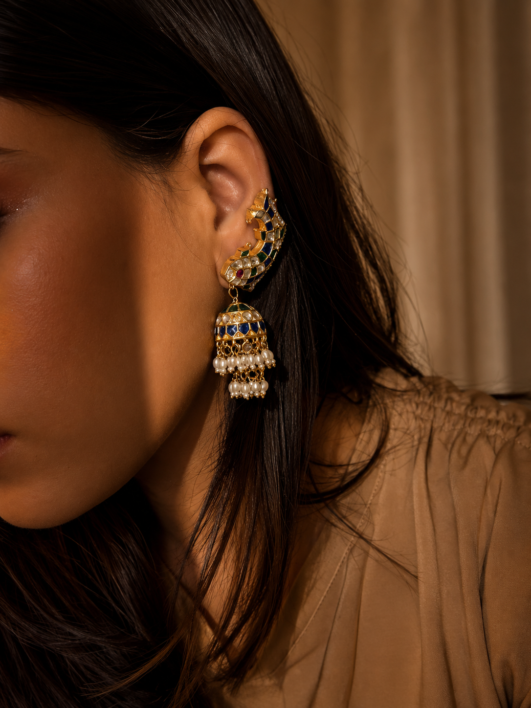 Royal meenakari kundan jhumka earrings with blue enamel detailing and pearl tassels.