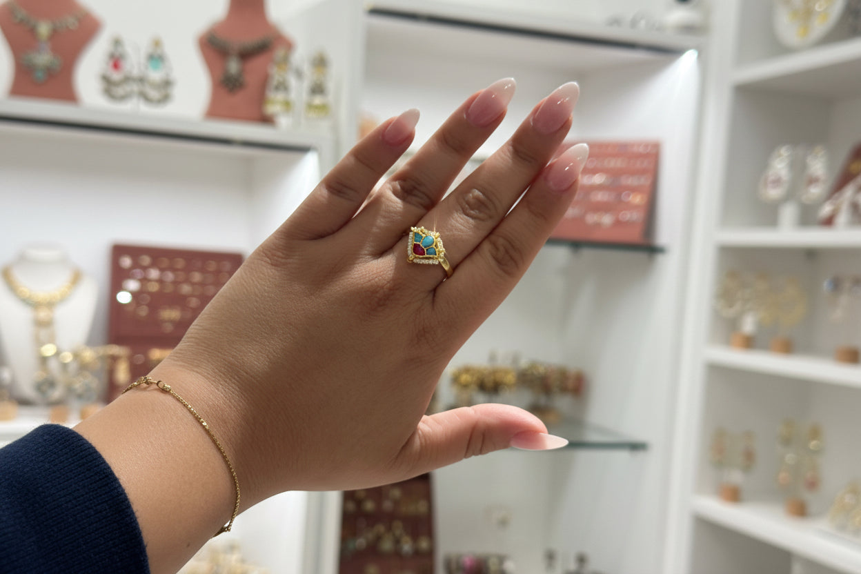 Hand wearing a ring with  firoza ring colorful gemstone against a blurred jewelry store background