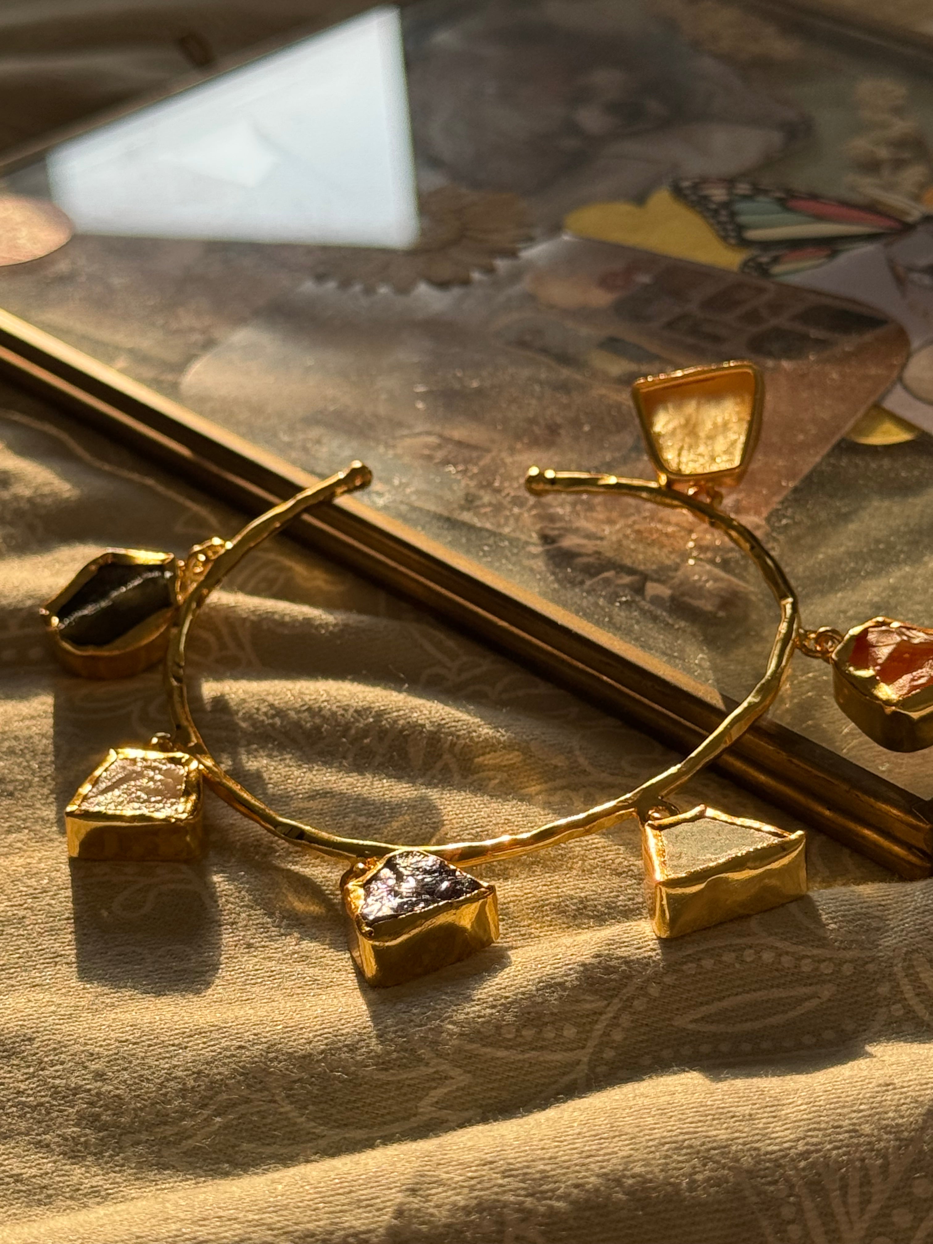 Gold jewelry with pendant on a textured surface