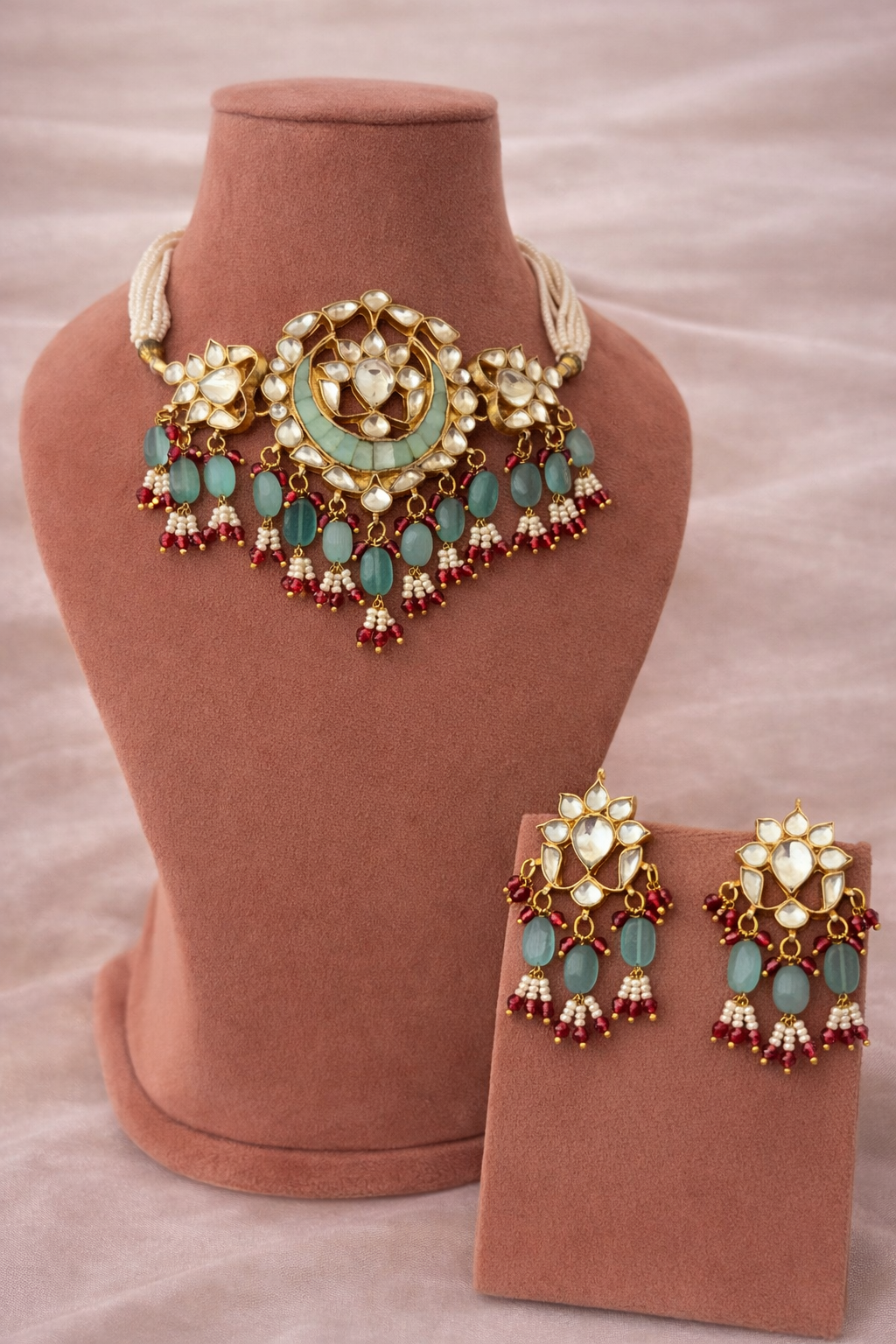 Jewelry set with necklace and earrings on a brown mannequin and stand.