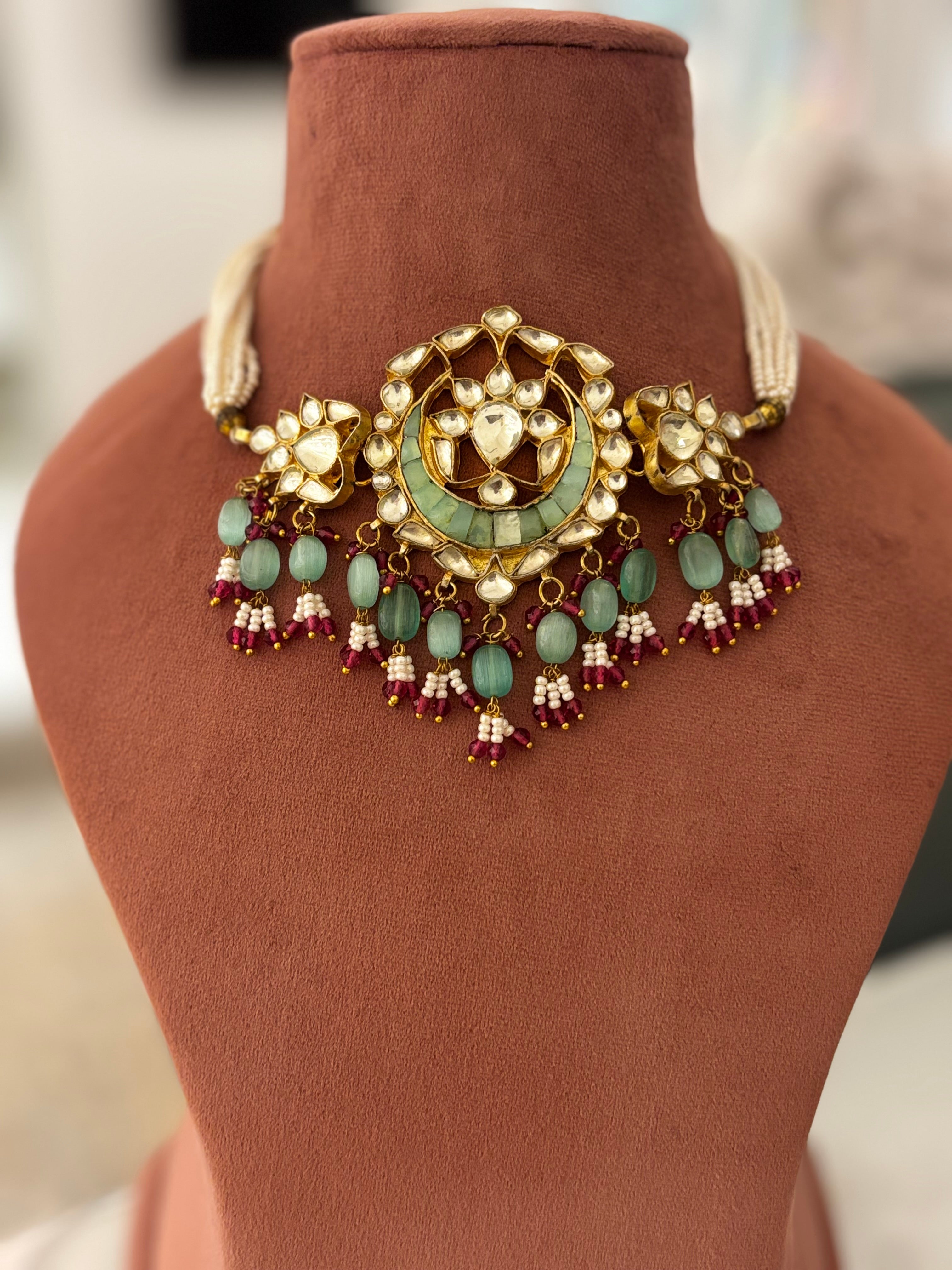 Jewelry set with necklace and earrings on a brown mannequin and stand.