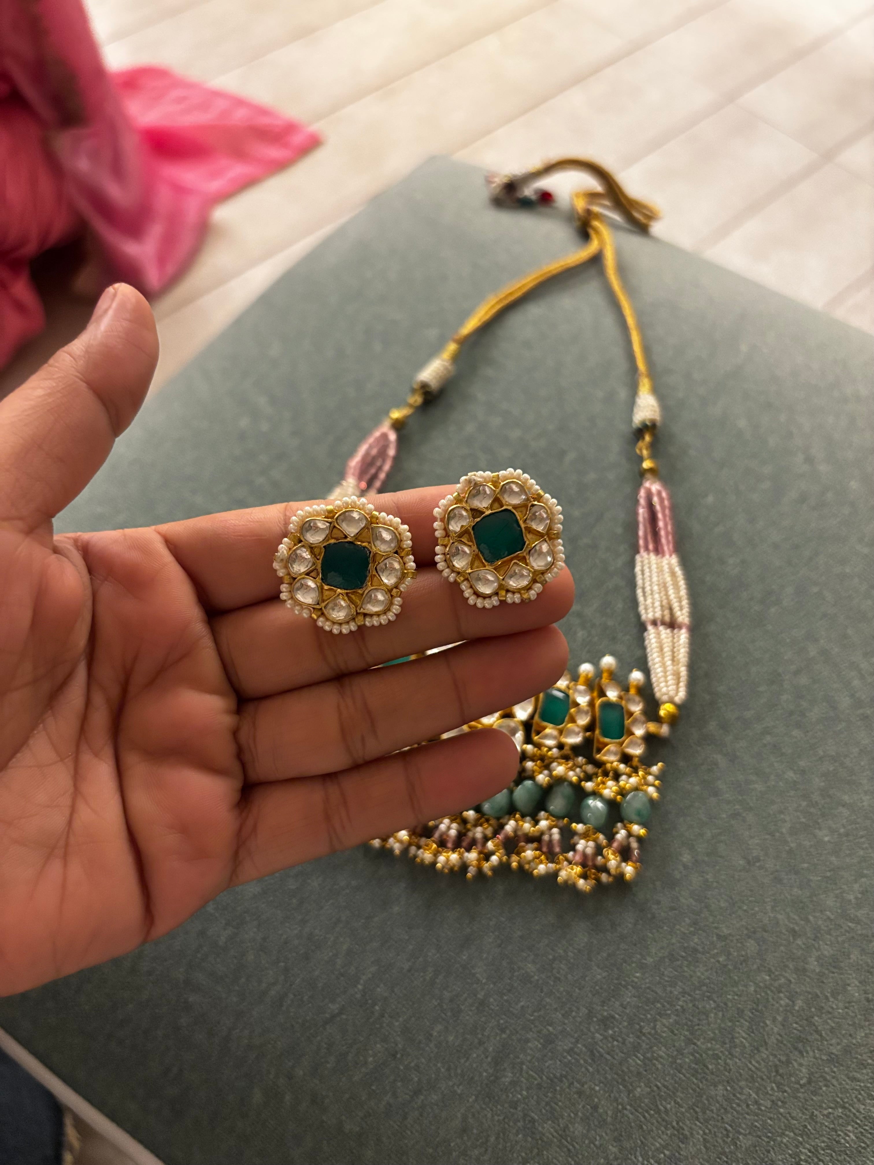 Handcrafted emerald green Polki choker necklace with pearl and pastel bead detailing, adjustable dori, and matching stud earrings by Naazuk Jewels.